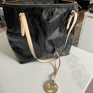 MK black patent tote. 2 exterior pockets and three interior pockets. Holds lots!
